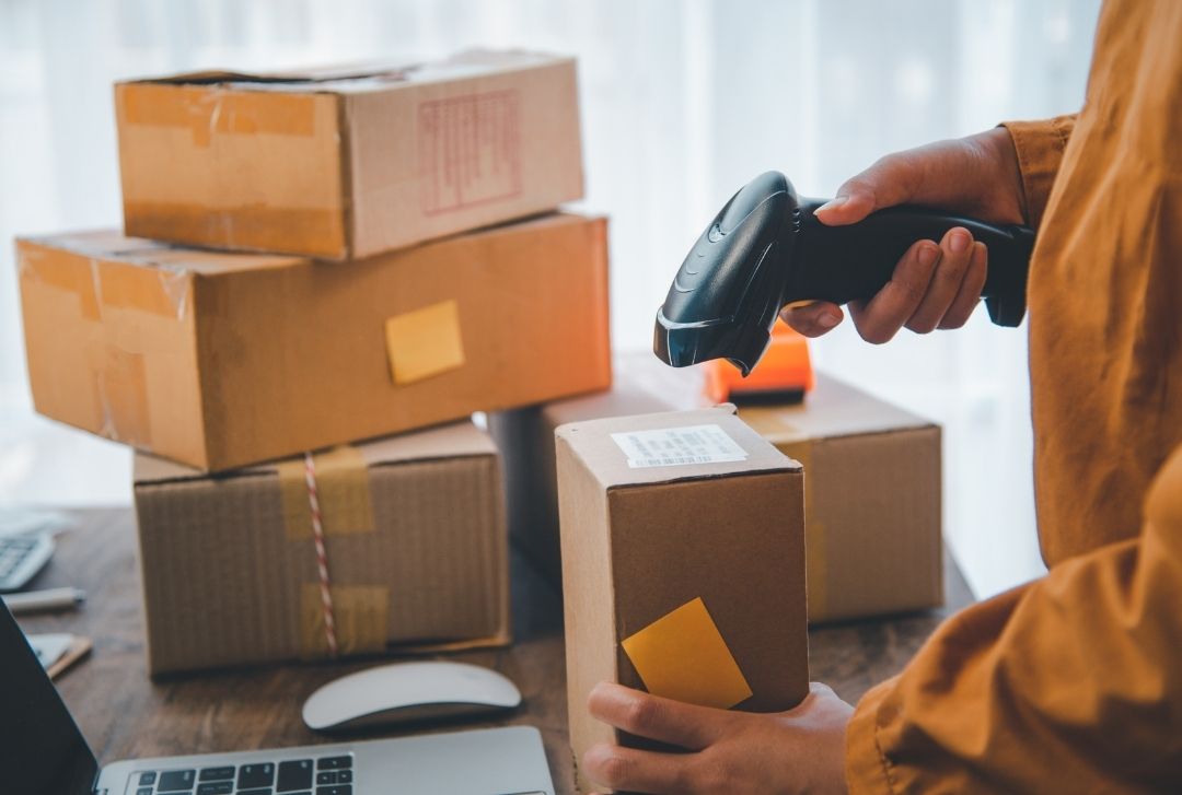 Gambar dari stok seseorang yang mengelola stok barang mmenggunakan scanner barcode